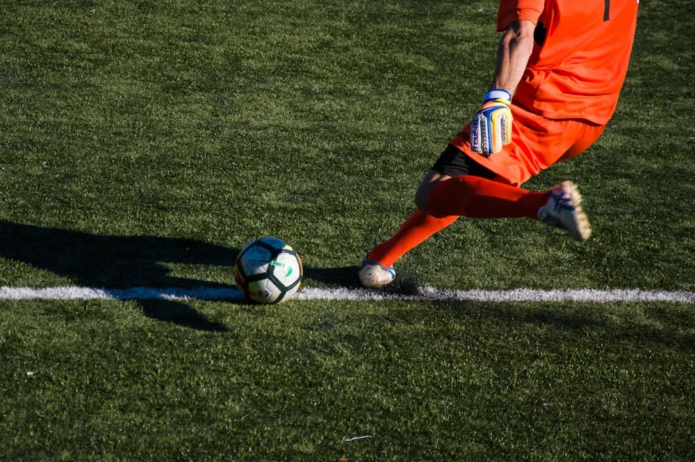 Joueur de football concentré sur le bord d'un terrain au coucher du soleil en Camargue